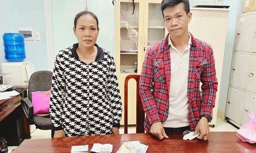 Anh Nguyễn Mạnh Đắc (phải) trả lại chiếc ví nhặt được trên đường đi làm cho chủ. Ảnh: Công an cung cấp