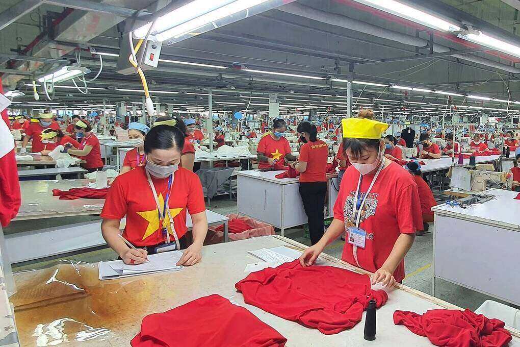 Công nhân Công ty TNHH Wooin Vina mặc áo đỏ in sao vàng trong ngày thứ 2 hằng tuần. Ảnh: Xuân Hào