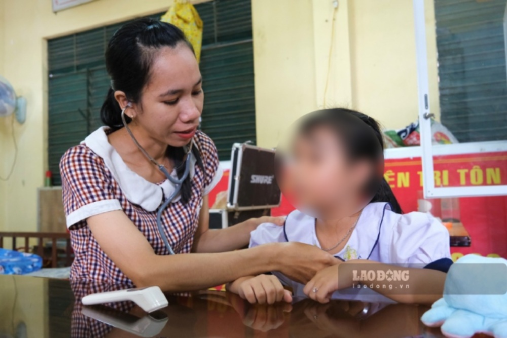 Chị Kim Lý Mone thực hiện công tác khám sức khỏe cho học sinh. Ảnh: Phong Linh.