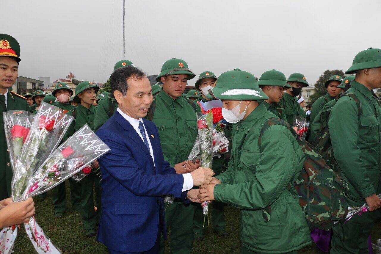 Ông Nguyễn Mạnh Cương - Chủ tịch LĐLĐ tỉnh Hoà Bình tặng hoa động viên tân binh trước khi lên đường làm nhiệm vụ. Ảnh: Khánh Linh