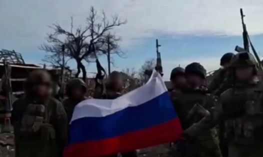 Ảnh trên Telegram được cho là chụp các binh sĩ vẫy cờ Nga giữa khu định cư bị tàn phá ở Lastochkino.