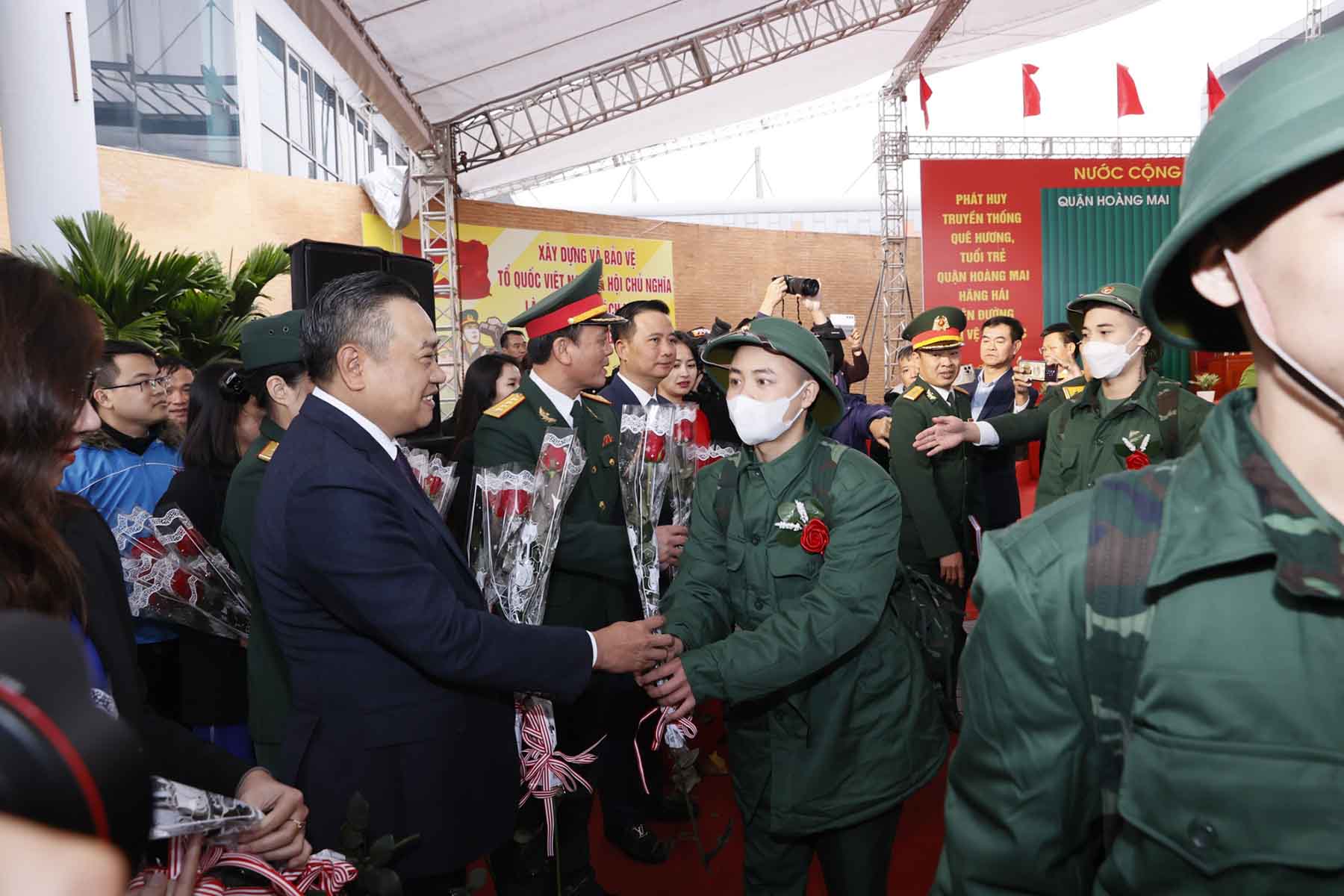 Chủ tịch UBND Thành phố Hà Nội Trần Sỹ Thanh tặng hoa, động viên các tân binh quận Hoàng Mai. Ảnh: Phạm Đông