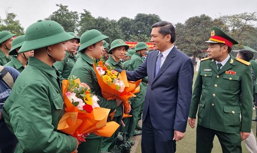 Phó Bí thư Tỉnh ủy Nghệ An Hoàng Nghĩa Hiếu tặng hoa chúc mừng tân binh lên đường nhập ngũ. Ảnh: Quang Đại