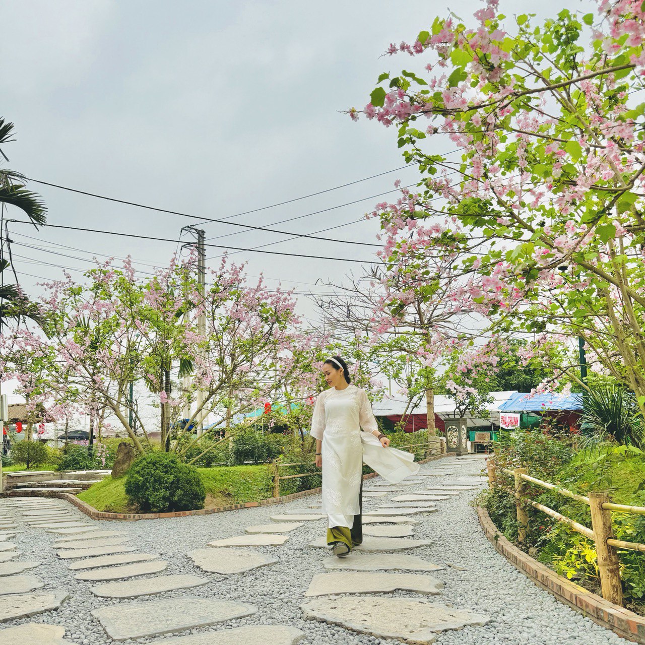 Lối vào chùa có nhiều cây xanh, được gắn thêm hoa giả, tô điểm cho không gian bừng thêm sức xuân.