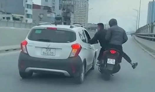 Hai thanh niên đi xe máy có hành vi gây gổ, hành hung người trên ôtô ở đường Vành đai 2 Hà Nội. Ảnh: Cắt từ clip
