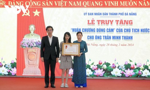 Phó Chủ tịch UBND TP Đà Nẵng trao Huân chương Dũng Cảm lại cho người thân bảo vệ Trần Minh Thành. Ảnh: Doãn Hùng