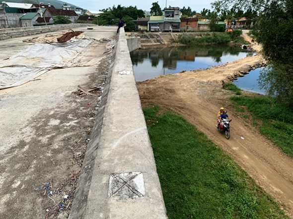 Trong lúc chờ cầu nối hai xã Hành Nhân - Hành Dũng hoàn thành, người dân phải vượt sông bằng đường đất nằm gần chân cầu. Ảnh: Ngọc Viên