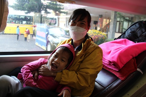 Nữ công nhân cùng con nhỏ hân hoan trên chuyến xe nghĩa tình, miễn phí. Ảnh: Thanh Tuấn 