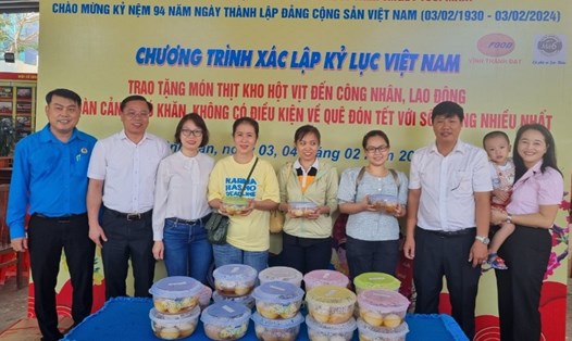 Ông Huỳnh Khắc Điệp - Bí thư Quận ủy quận Bình Tân (thứ hai từ trái qua), đại diện LĐLĐ quận Bình Tân, Công ty Tươi Mart trao tượng trưng phần thịt kho hột vịt cho người lao động. Ảnh: Nam Dương
