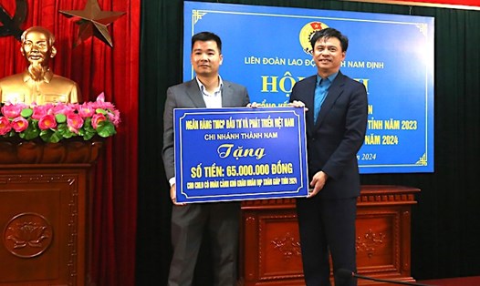 Đại diện Ngân hàng Thương mại Cổ phần Đầu tư và phát triển Việt Nam chi nhánh Thành Nam trao số tiền 65 triệu đồng cho lãnh đạo LĐLĐ tỉnh Nam Định (bên phải). Ảnh: CĐNĐ