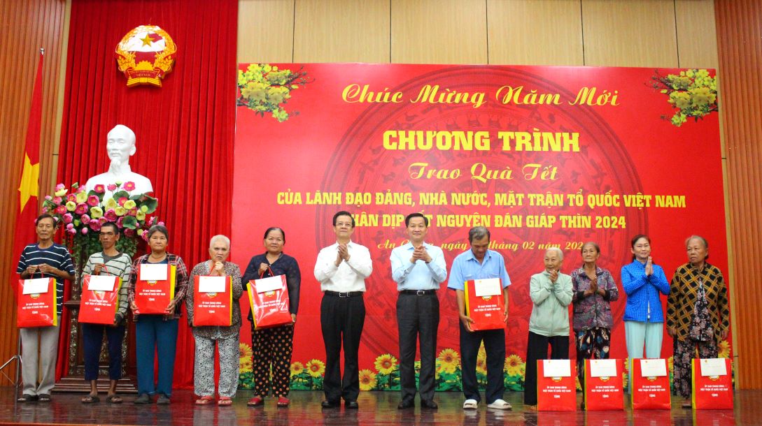 Phó Thủ tướng Lê Minh Khái và Bí thư Tỉnh ủy An Giang Lê Hồng Quang trao quà Tết cho hộ chính sách. Ảnh: Lục Tùng