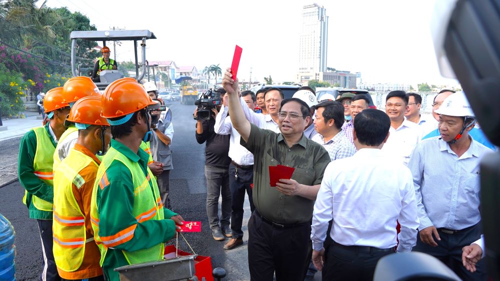 Nơi đang thảm nhựa, Thủ tướng Chính phủ Phạm Minh Chính đã ra tận chỗ làm để động viên, lì xì cho công nhân.