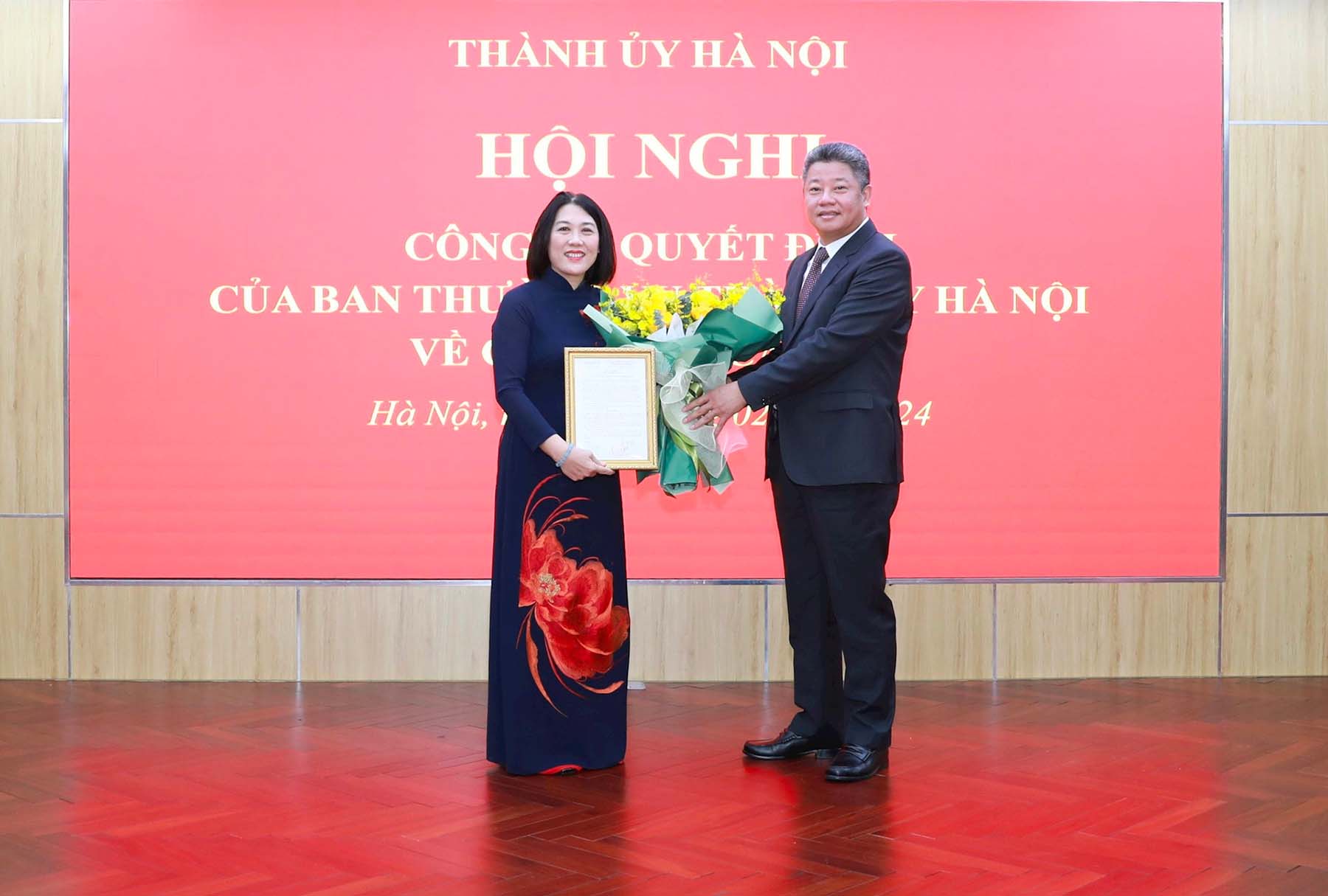 Phó Chủ tịch UBND Thành phố Hà Nội Nguyễn Mạnh Quyền trao quyết định của UBND thành phố và tặng hoa chúc mừng bà Nguyễn Thị Vân. Ảnh: Quang Thái