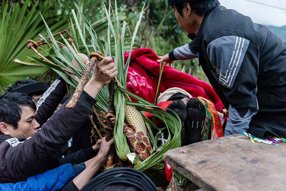 Sau khi “ngã” vào, thầy cúng lập tức lấy chăn che “gói” tròn lại kín mít như hình ảnh của một đứa bé trong bào thai được đầu thai lần thứ hai.