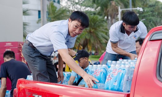 Ban tổ chức hỗ trợ bà con xếp đồ đạc lên xe, chuẩn bị nước uống dọc đường cho đồng hương. Ảnh: Thái Bình