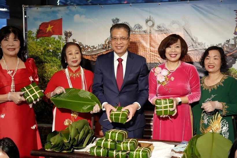 Đại sứ Việt Nam tại Liên bang Nga Đặng Minh Khôi (giữa) và Phu nhân (thứ 2, phải qua) cùng bà con cộng đồng gói bánh chưng. Ảnh: TTXVN