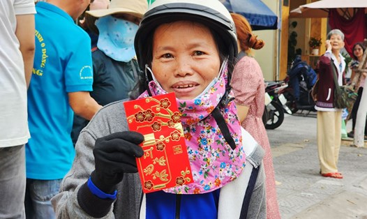 Người lao động được tặng lì xì khi về quê ăn Tết trên chuyến xe 0 đồng tại Đà Nẵng. Ảnh: Thùy Trang