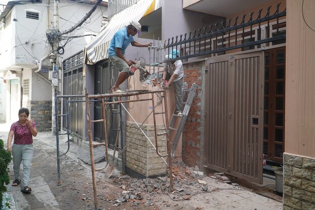 Người dân phường 4, quận Phú Nhuận đang tháo dỡ cổng để bàn giao lại mặt bằng cho địa phương. Ảnh:  Anh Tú