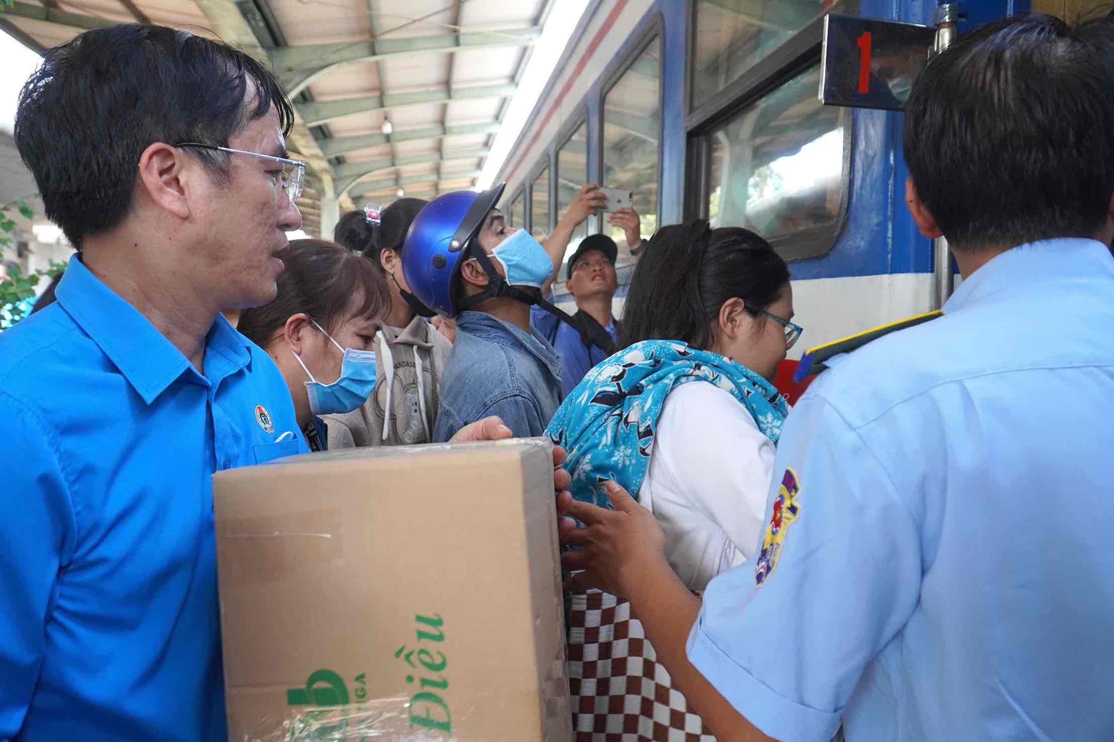 Cán bộ LĐLĐ tỉnh Đồng Nai hỗ trợ đoàn viên người lao động đưa hành lý lên tàu. Ảnh: Hà Anh Chiến
