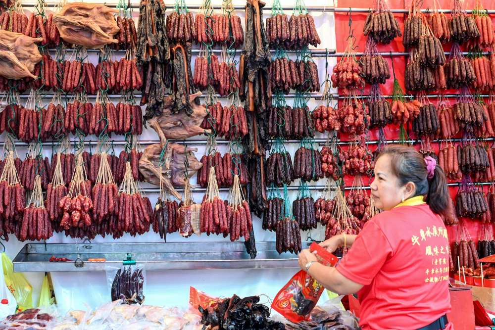 Người bán hàng bày bán thịt khô để bán tại một quầy hàng trên đường phố ở khu Chinatown của Singapore trước Tết Nguyên đán. Ảnh: AFP