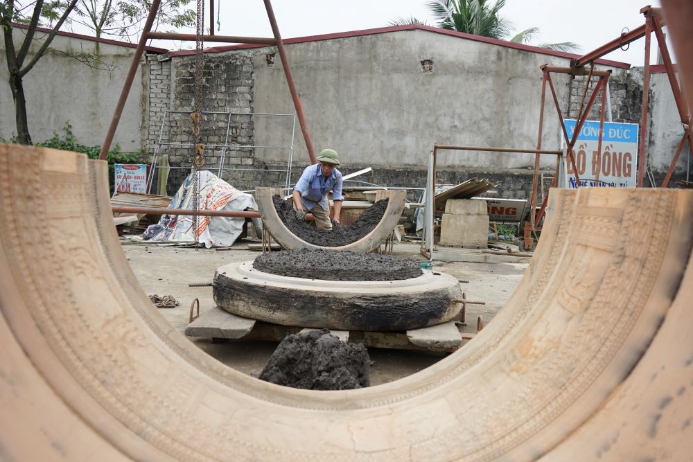 Thợ đúc trống đồng miệt mài làm việc tại xưởng đúc đồng của Nghệ nhân ưu tú Nguyễn Bá Châu. Ảnh: Quách Du