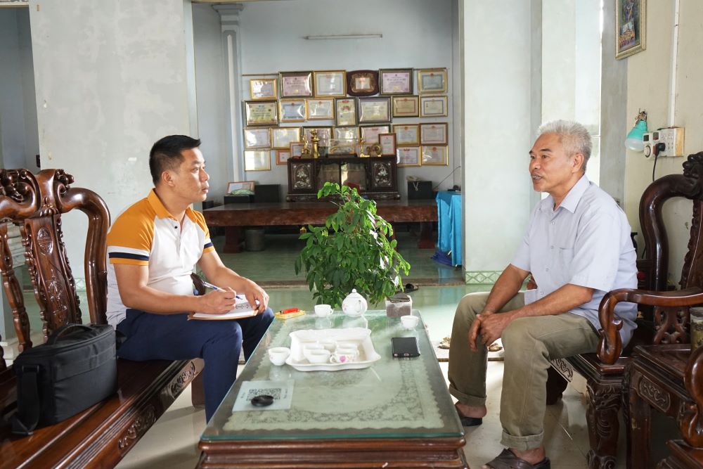 Nghệ nhân ưu tú Nguyễn Bá Châu chia sẻ với phóng viên về quãng thời gian nghiên cứu và đúc thành công trống đồng. Ảnh: Q.D