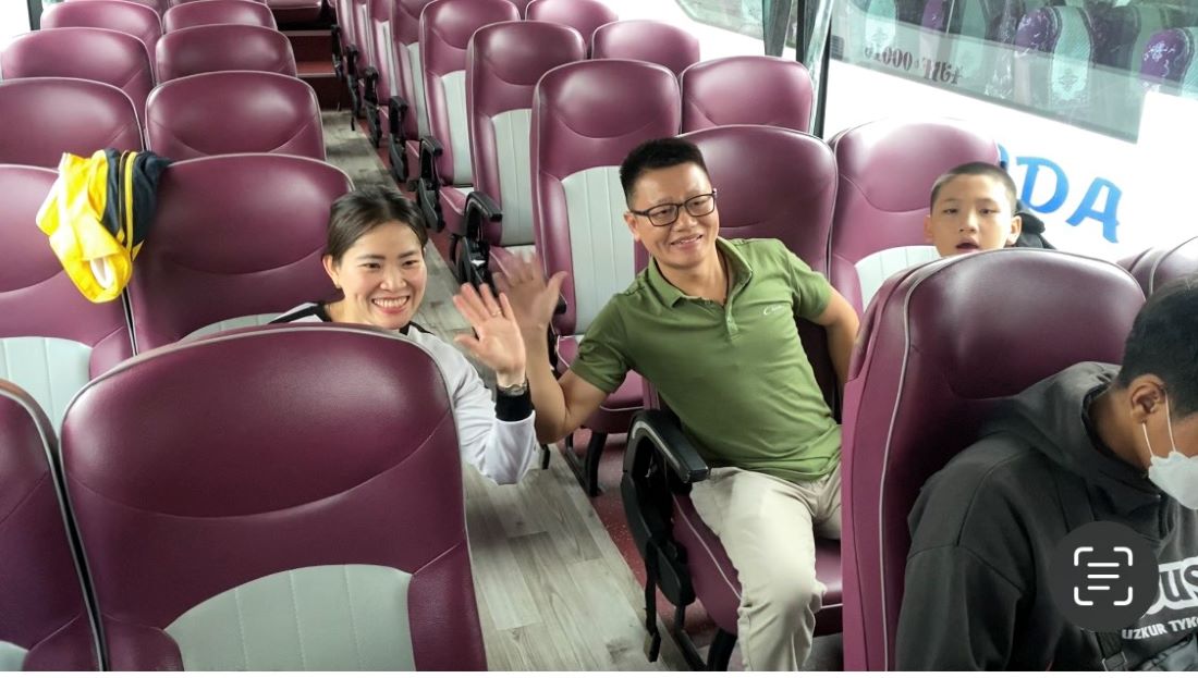 Anh Thái Mạnh Hưng cùng gia đình vẫy tay chào trên chuyến xe Công đoàn. Ảnh: Văn Trực