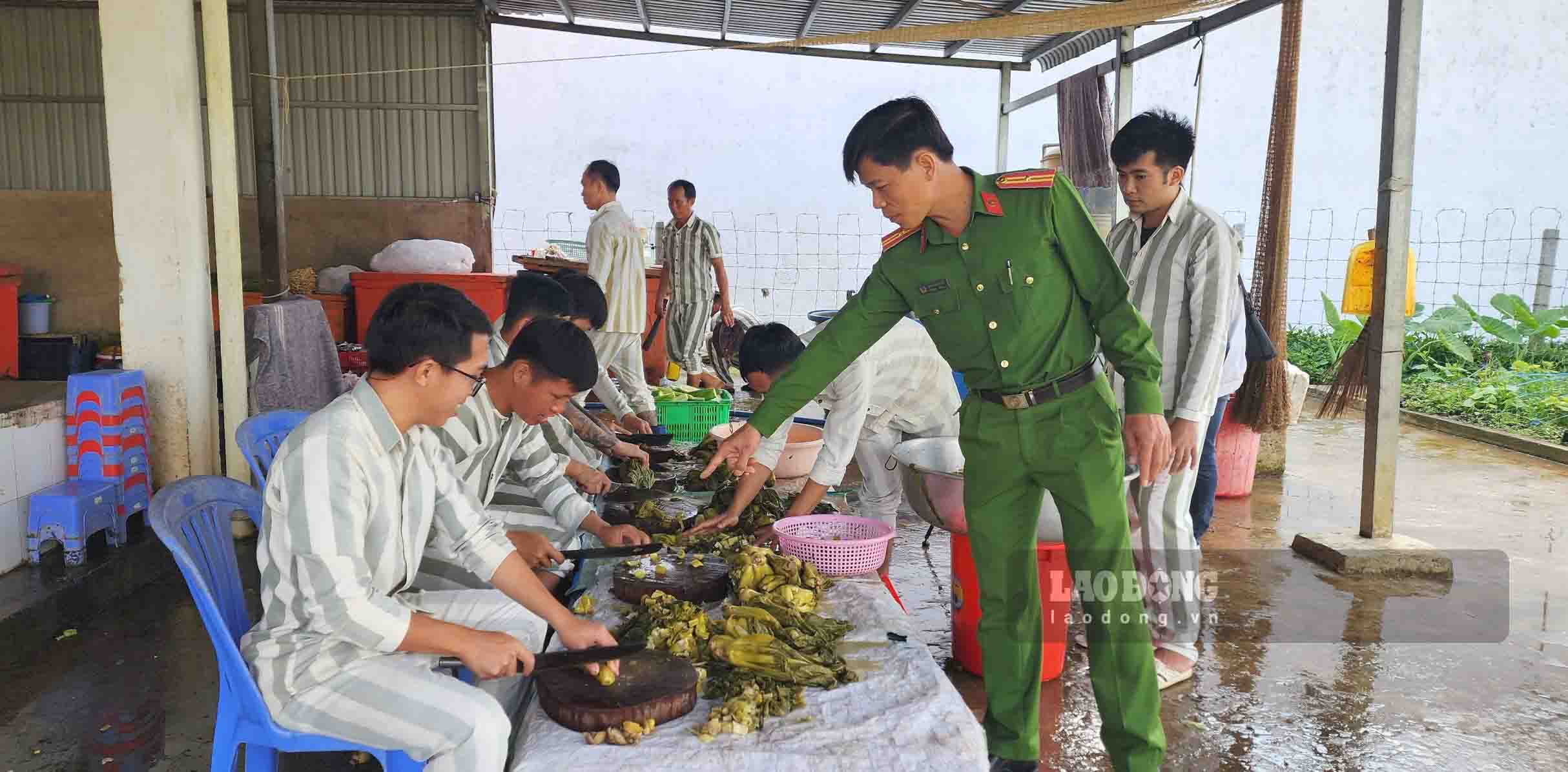 Cán bộ quản giáo hướng dẫn cho phạm nhân làm các món ăn chuẩn bị cho ngày Tết. Ảnh: Xuân Nhi   