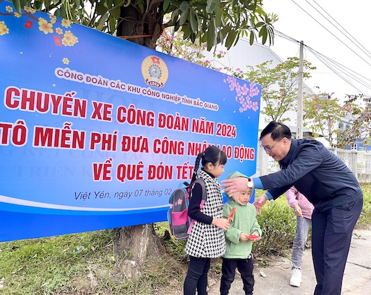 Ông Nguyễn Mạnh Hùng - Phó Chủ tịch Liên đoàn Lao động tỉnh trao lì xì cho các cháu là con đoàn viên, người lao động trước khi xe khởi hành. Ảnh: Hạnh Chi. 