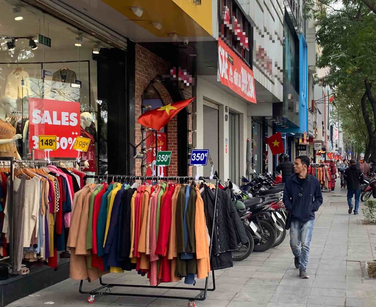 Cửa hàng đã bày quần áo ra ngoài vỉa hè nhằm thu hút sự chú ý của người đi đường. Ảnh: Nhật Minh