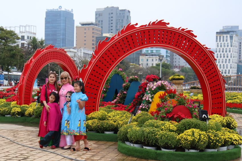 Một gia đình chụp hình với cụm trang trí bằng hoa tươi.