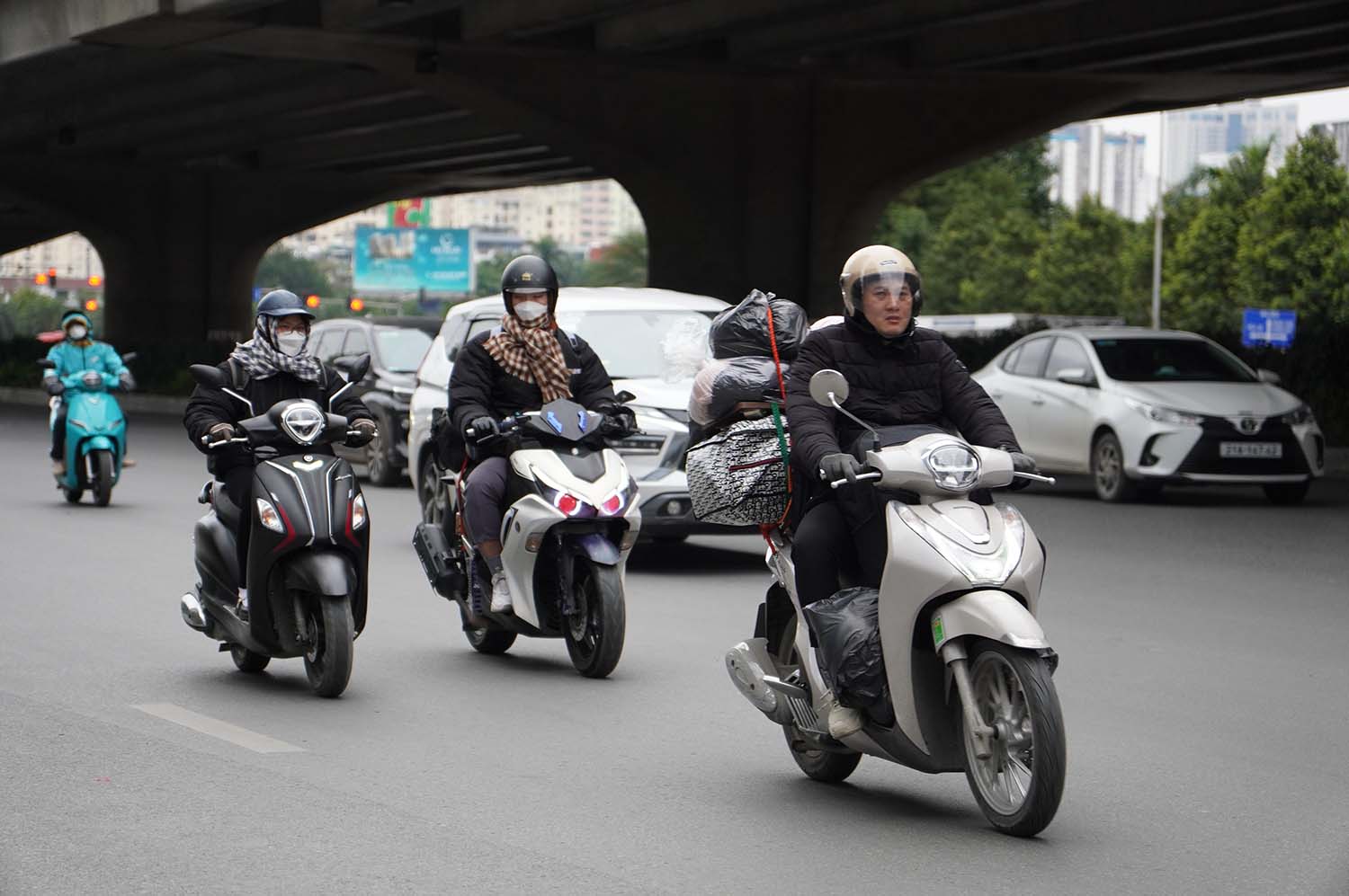 Nhiều người dân lỉnh kỉnh đi xe máy về quê nghỉ Tết. Ảnh: Hữu Chánh