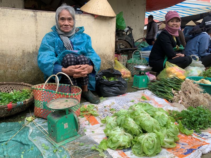 Một cụ bà mang những mớ rau trồng được đến chợ bán. Ảnh: Quách Du