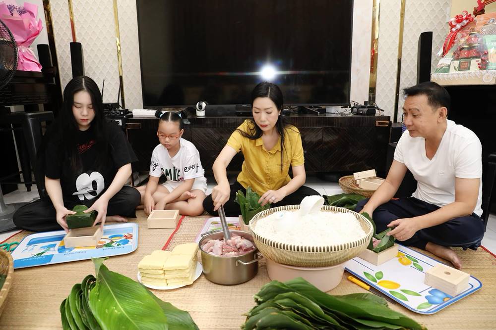 Trịnh Kim Chi cùng chồng doanh nhân và các con gói bánh chưng tại nhà. Ảnh: Facebook Trịnh Kim Chi