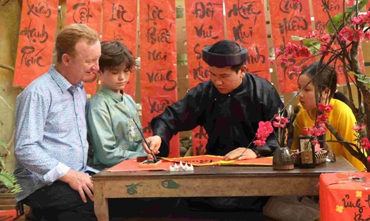 Du khách nước ngoài thích thú trải nghiệm những hoạt động trong ngày Tết khi du lịch ở Huế. Ảnh: Quảng An.