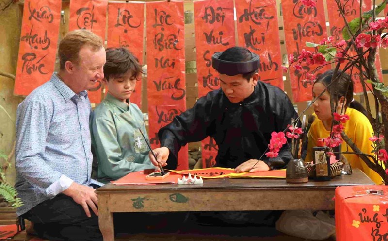 Du khách nước ngoài thích thú trải nghiệm những hoạt động trong ngày Tết khi du lịch ở Huế. Ảnh: Quảng An.