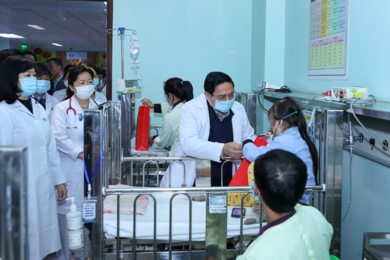 Thủ tướng Chính phủ Phạm Minh Chính tặng quà và chia sẻ với các bệnh nhân, người nhà bệnh nhân vẫn phải ở bệnh viện mà không được về nhà đón Tết. Ảnh: Nhật Bắc  
