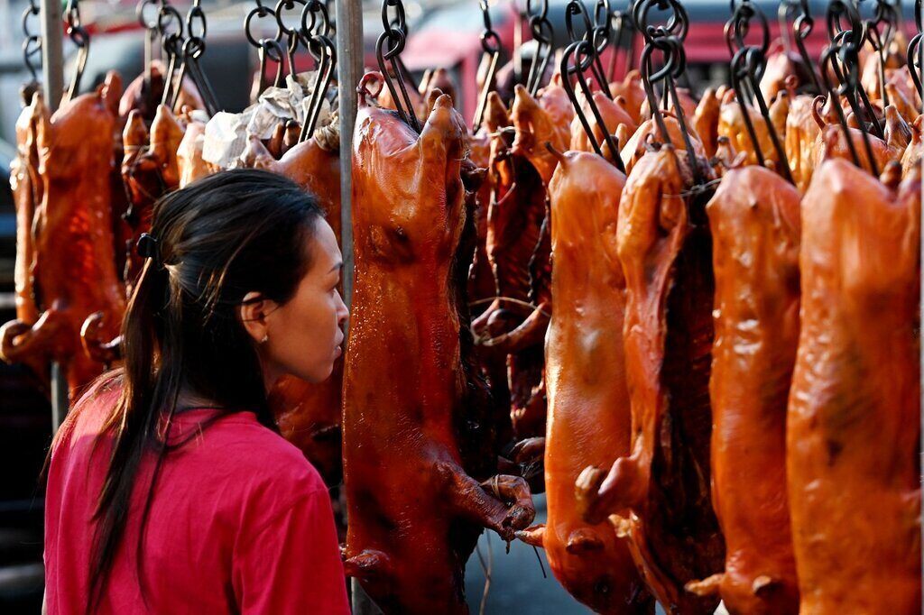 Khách hàng mua lợn quay bày bán tại một khu chợ ở Phnom Penh, Campuchia ngày 9.2.2024, tức ngày 30 Tết Giáp Thìn. Ảnh: AFP 