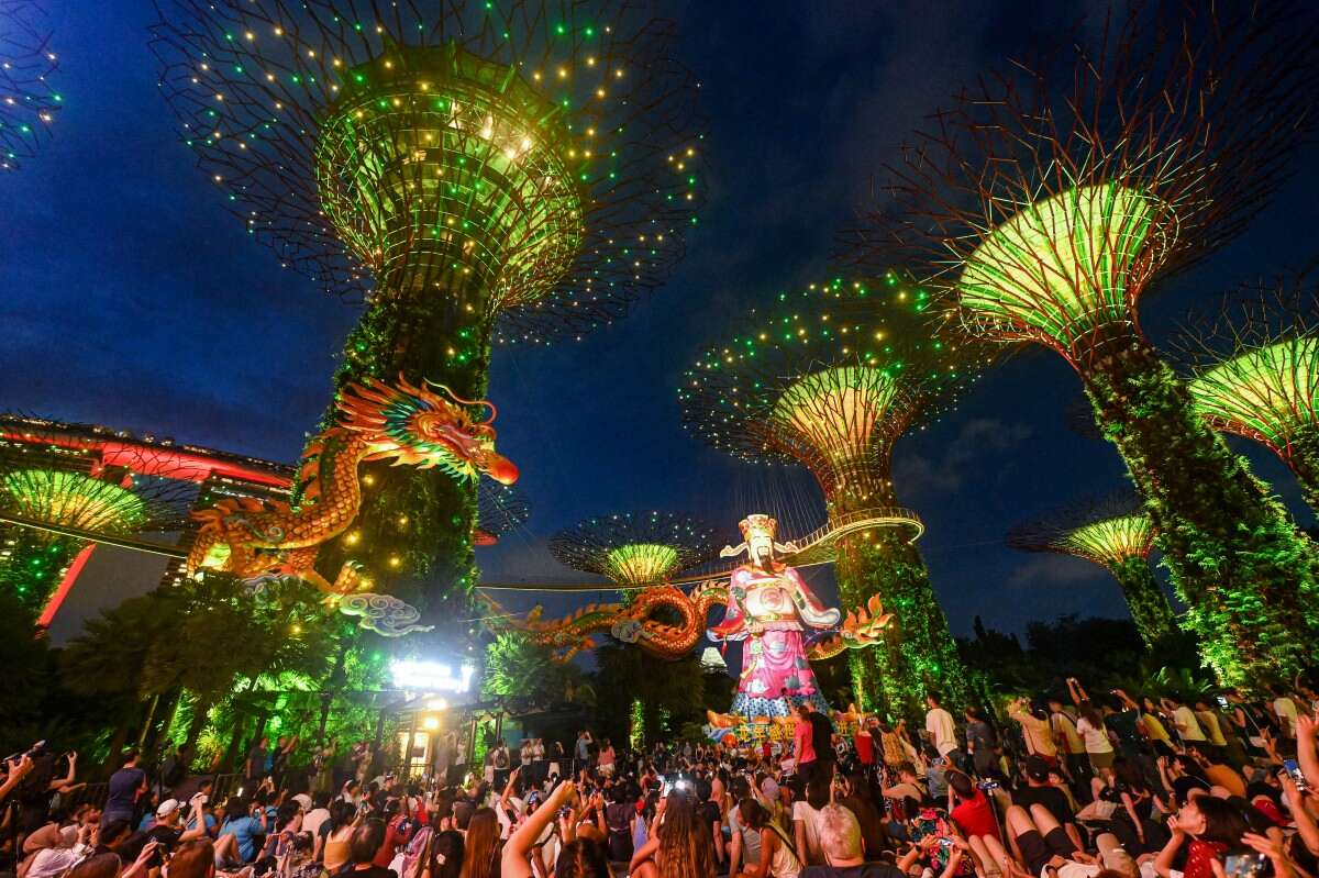 Du khách xem chương trình biểu diễn có hình con rồng dài 140 mét và thần tài tại khu đài quan sát siêu cây của Gardens by the Bay ở Singapore tối 7.2. Ảnh: AFP