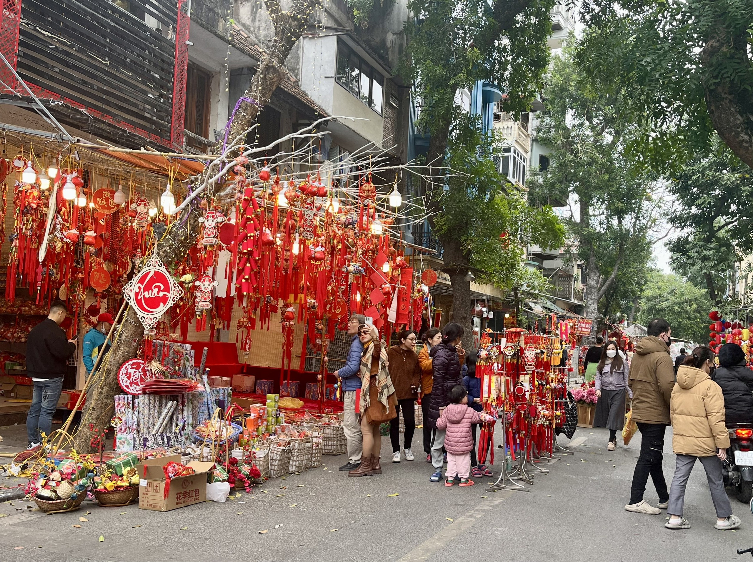 Khu vực phố hàng mã bày bán nhiều loại đồ trang trí Tết đỏ rực, thu hút người dân Thủ đô và cả khách quốc tế đến tham quan, mua sắm.