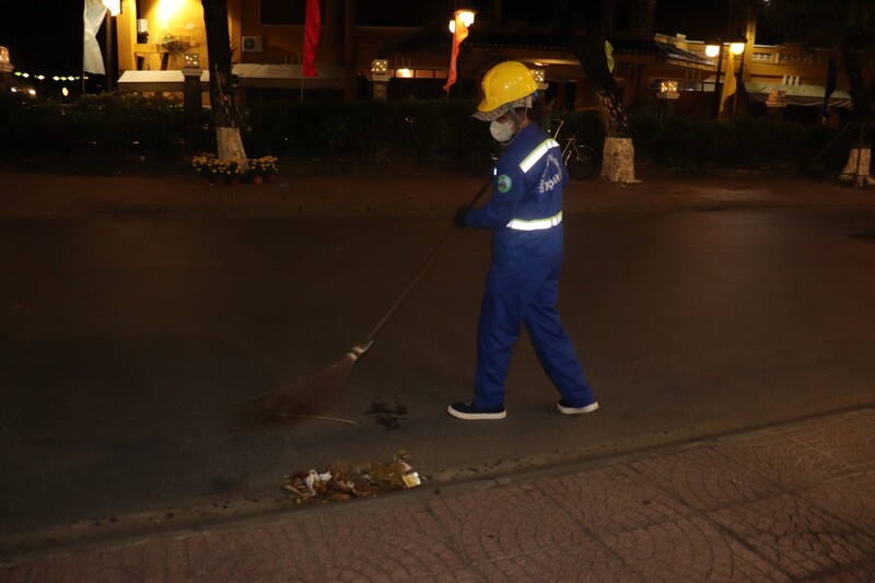 Những công nhân môi trường tại Hội An đón giao thừa ngoài đường. Ảnh: Nguyễn Linh