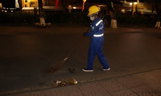 Những công nhân môi trường tại Hội An đón giao thừa ngoài đường. Ảnh: Nguyễn Linh