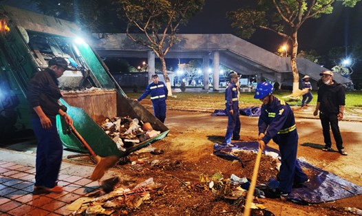 Có khoảng 100 người lao động dọn vệ sinh môi trường chợ hoa Đà Nẵng đêm 30 Tết. Ảnh: Thùy Trang