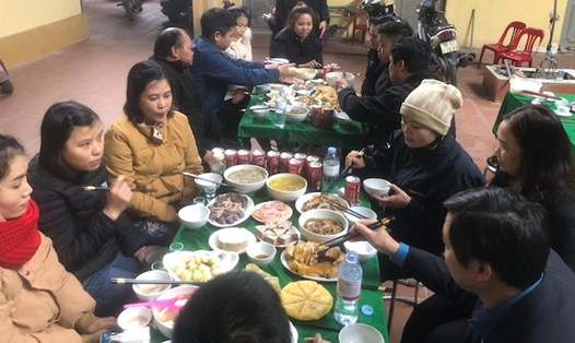 Công nhân ở lại trong những ngày Tết Nguyên đán chung vui bữa cơm tất niên trong khuôn viên nhà trọ của ông Nguyễn Bá Quang. Ảnh: Bảo Hân 