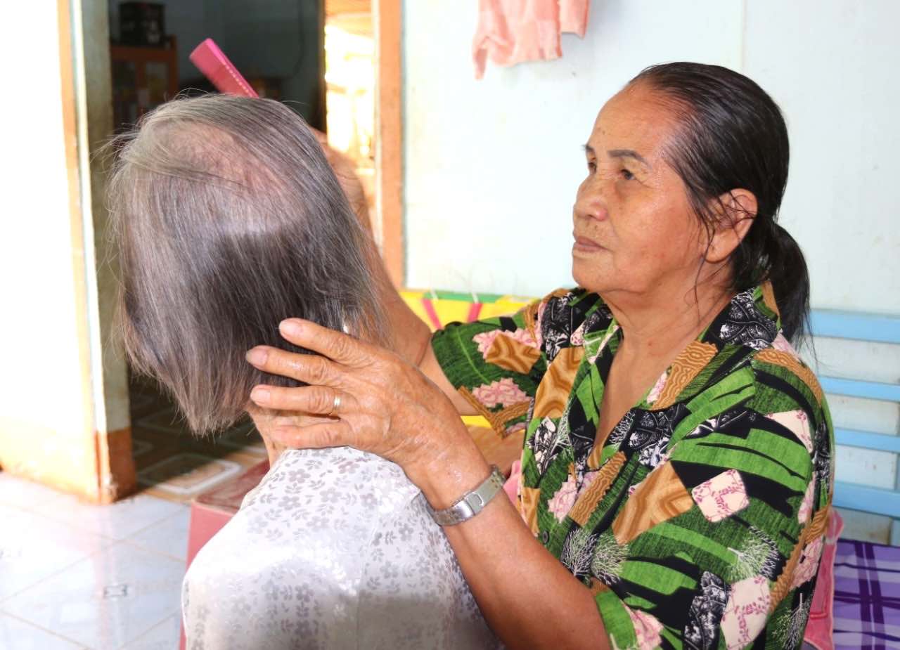 Bà Ninh đang chải tóc cho mẹ là cụ Trịnh Thị Khơng. Ảnh: Hà Anh Chiến