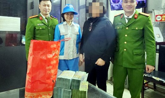 Công an quận Hoàn Kiếm cùng đại diện nhân viên thu gom rác trao trả số tiền bị mất cho chủ nhân. Ảnh: Dũng Hiệp