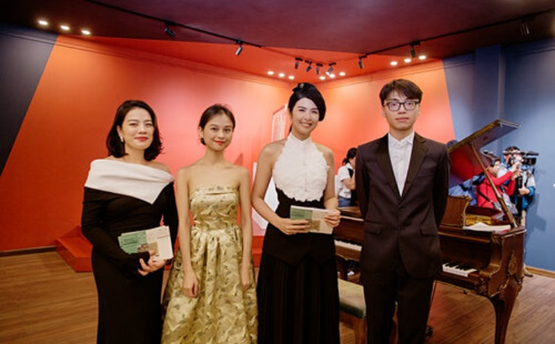 Hoa hậu Ngọc Hân bên nhà sưu tập/ pianist Trần Lê Bảo Quyên (váy quây vàng) và em trai cô, nghệ sĩ piano Trần Lê Quang Tiến tại triển lãm. Ảnh: Nhân vật cung cấp