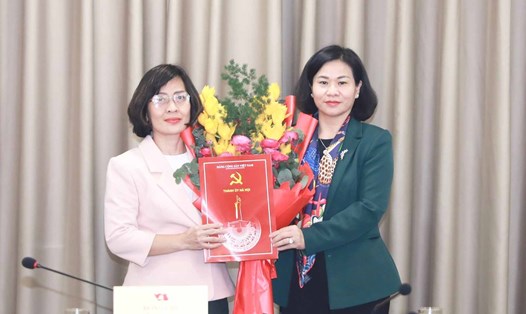 Phó Bí thư Thường trực Thành ủy Hà Nội Nguyễn Thị Tuyến trao quyết định và tặng hoa cho bà Nguyễn Tố Quyên. Ảnh: Quang Thái