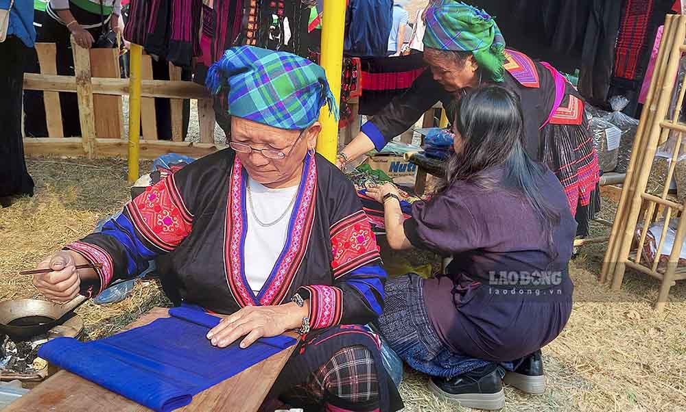 Một phụ nữ dân tộc Mông thể hiện tay nghề vẽ sáp ong - một trong những công đoạn tạo ra miếng vải thổ cẩm chứa nhiều nét văn của dân tộc mình.