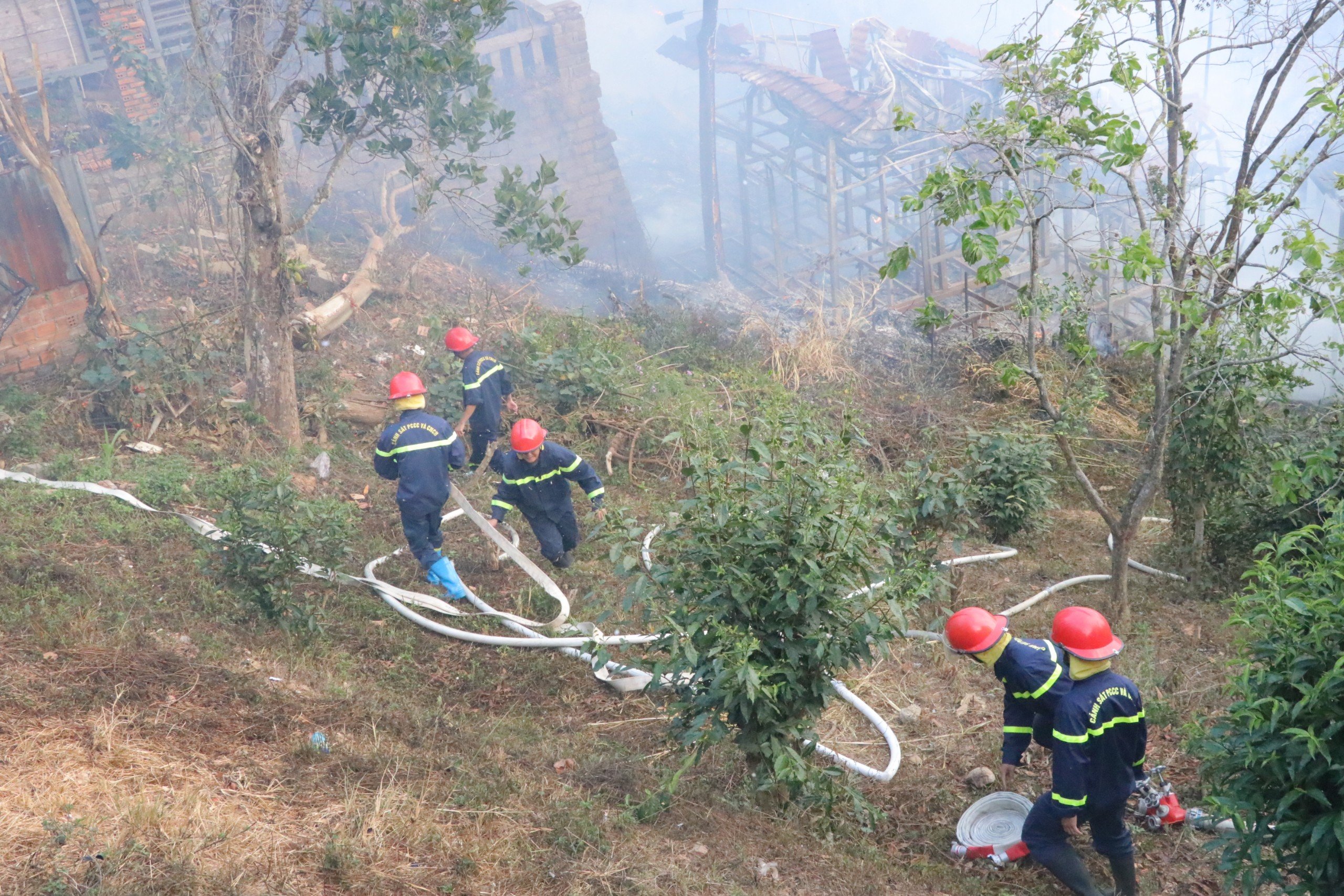 Lực lượng Cảnh sát Phòng cháy chữa cháy và Cứu nạn cứu hộ không để cháy lan sang những ngôi nhà đang có người dân sinh sống ngay gần đó. Ảnh: Mai Hương